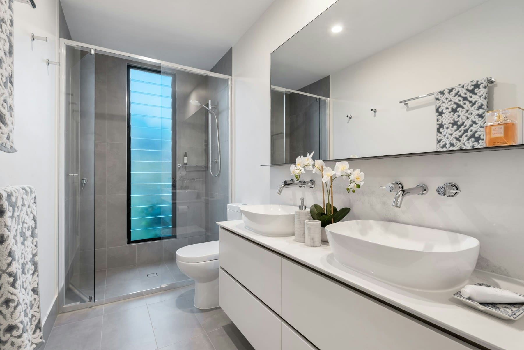 Clean modern bathroom with spotless tiles and fixtures.