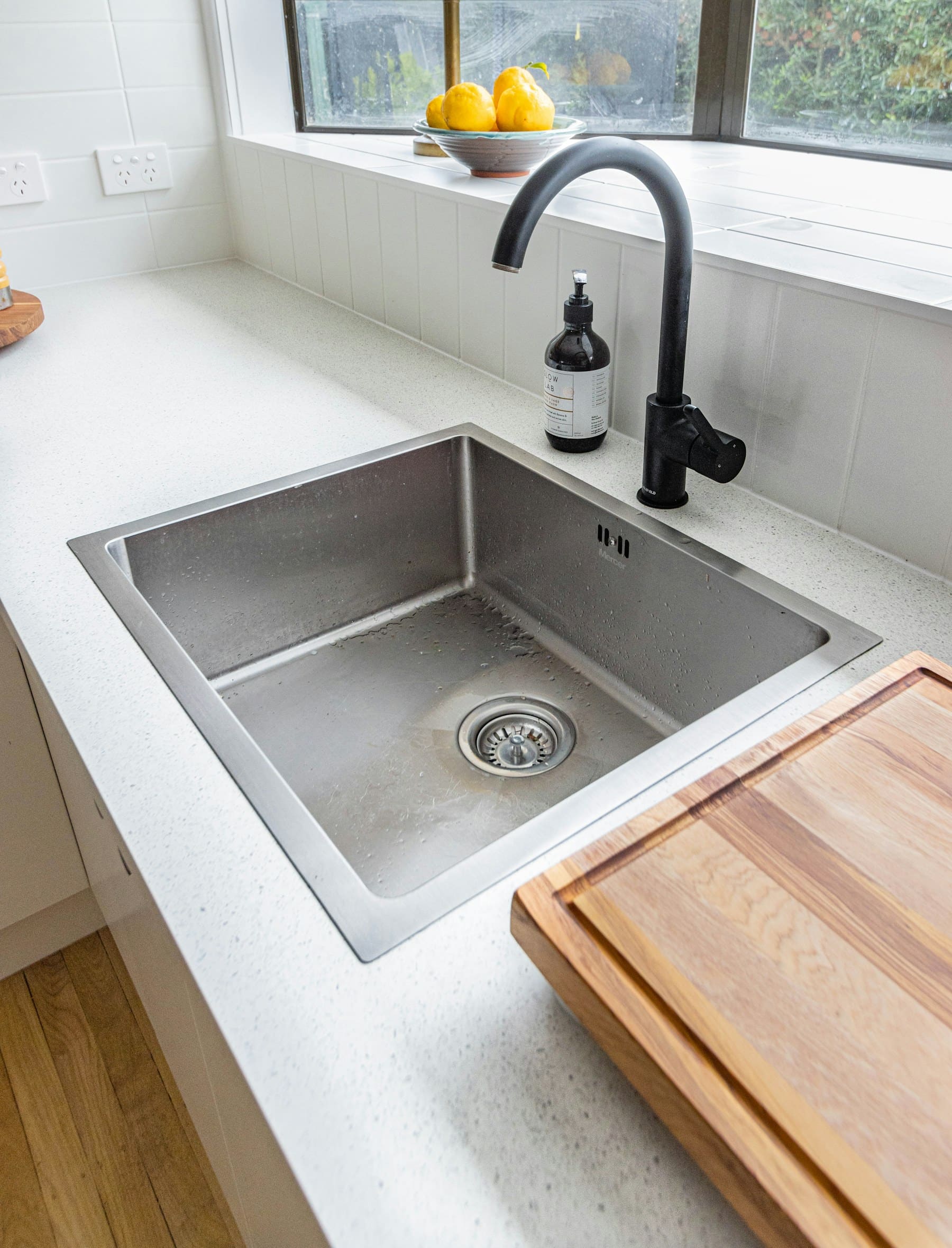 Polished kitchen tap and sink after detailed cleaning.